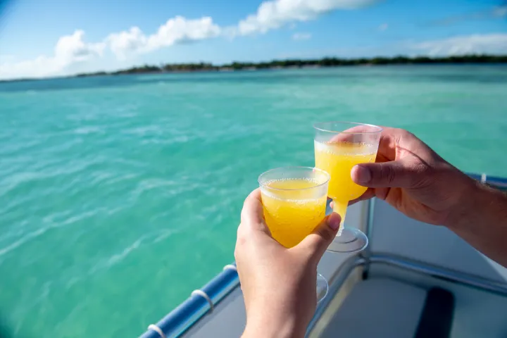 a glass of orange juice next to a cup of water